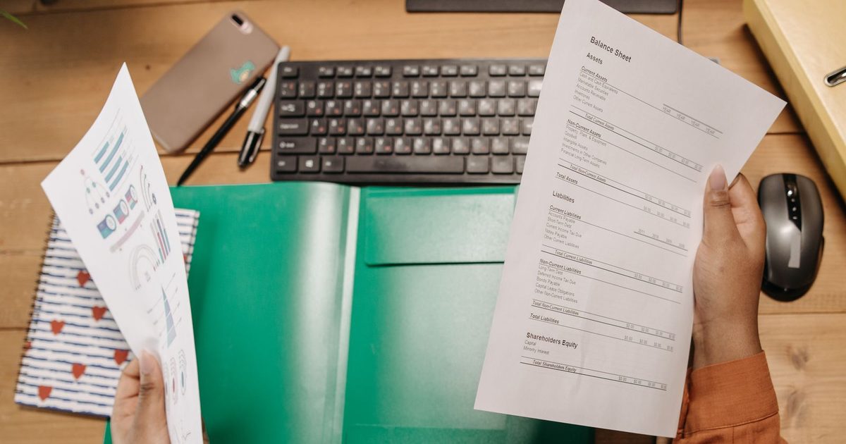 Auditor reviewing balance sheets and financial statements at a desk