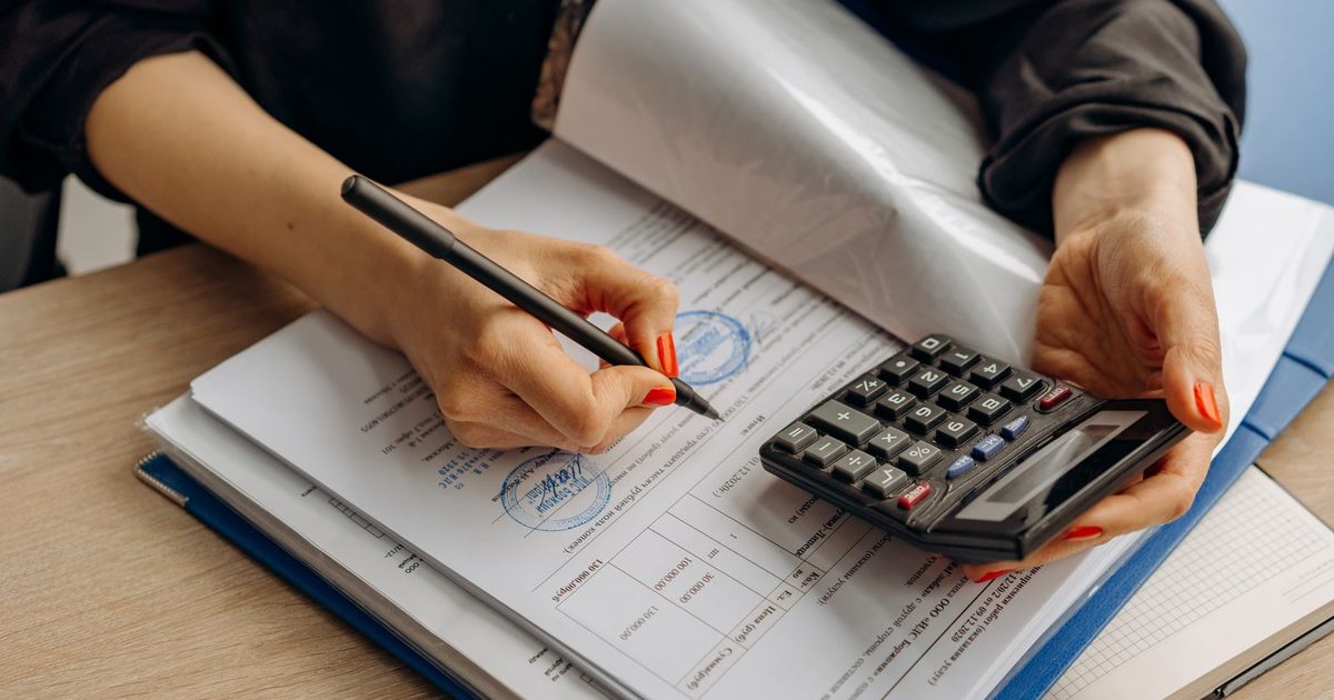Accountant working through documents with a calculator