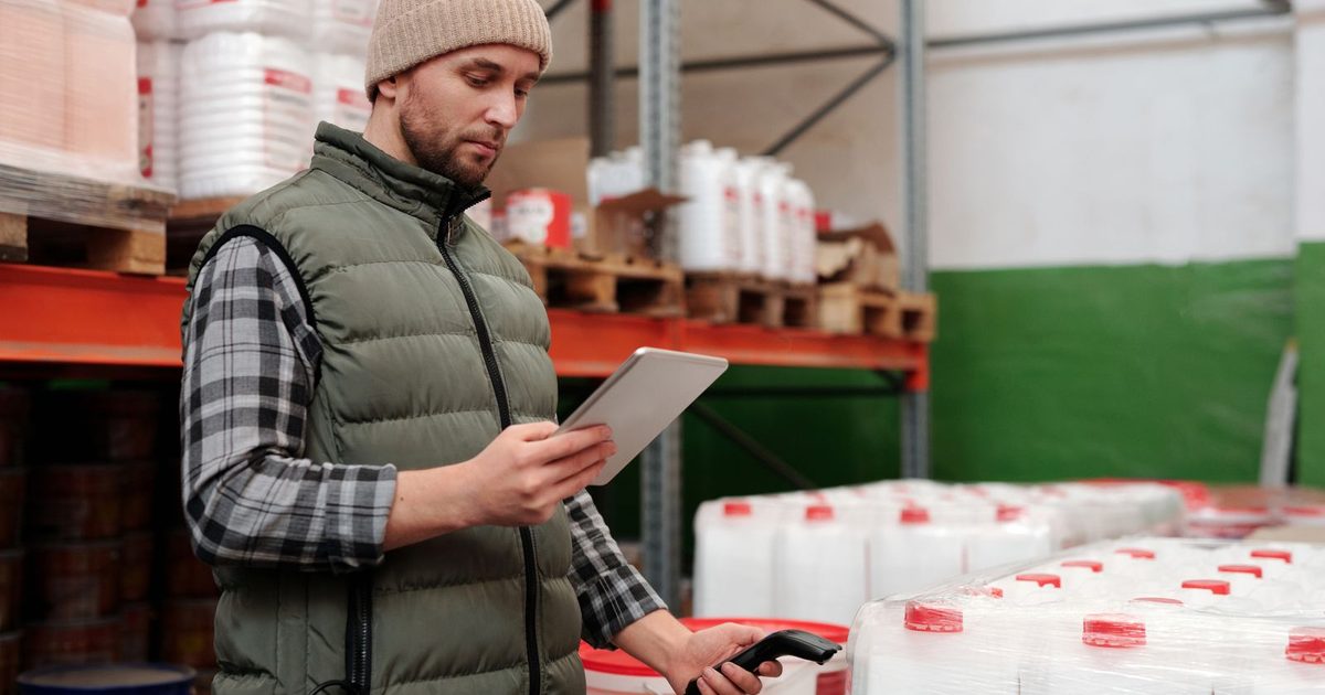 Warehouse worker checking stock with a tablet and barcode scanner